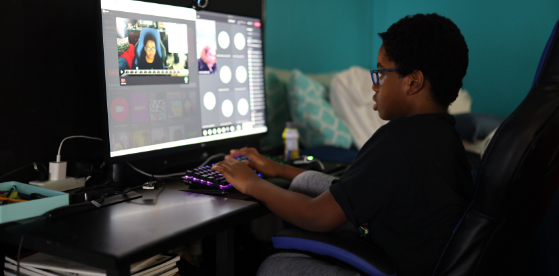 Child using a keyboard looking at monitor