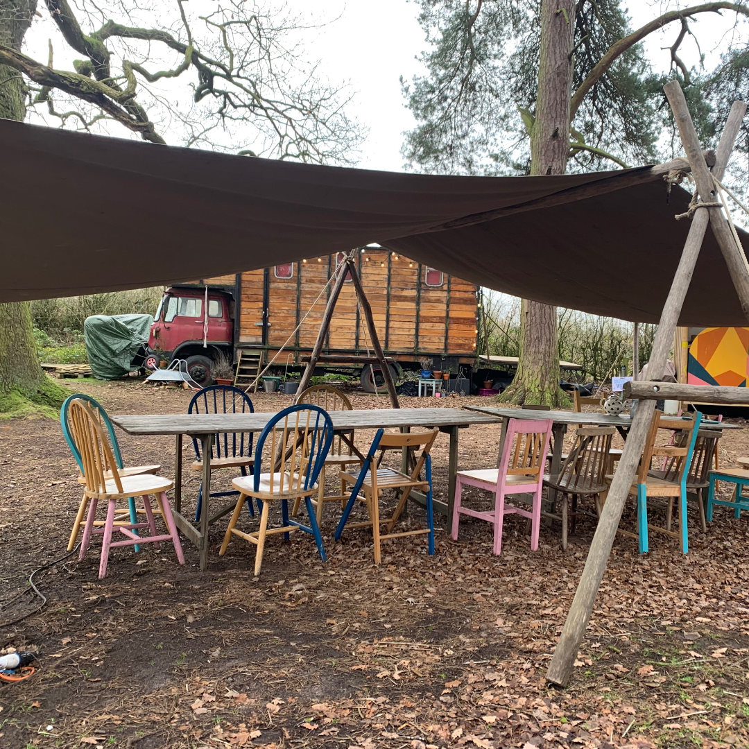 A table and chairs surrounded by woodland 