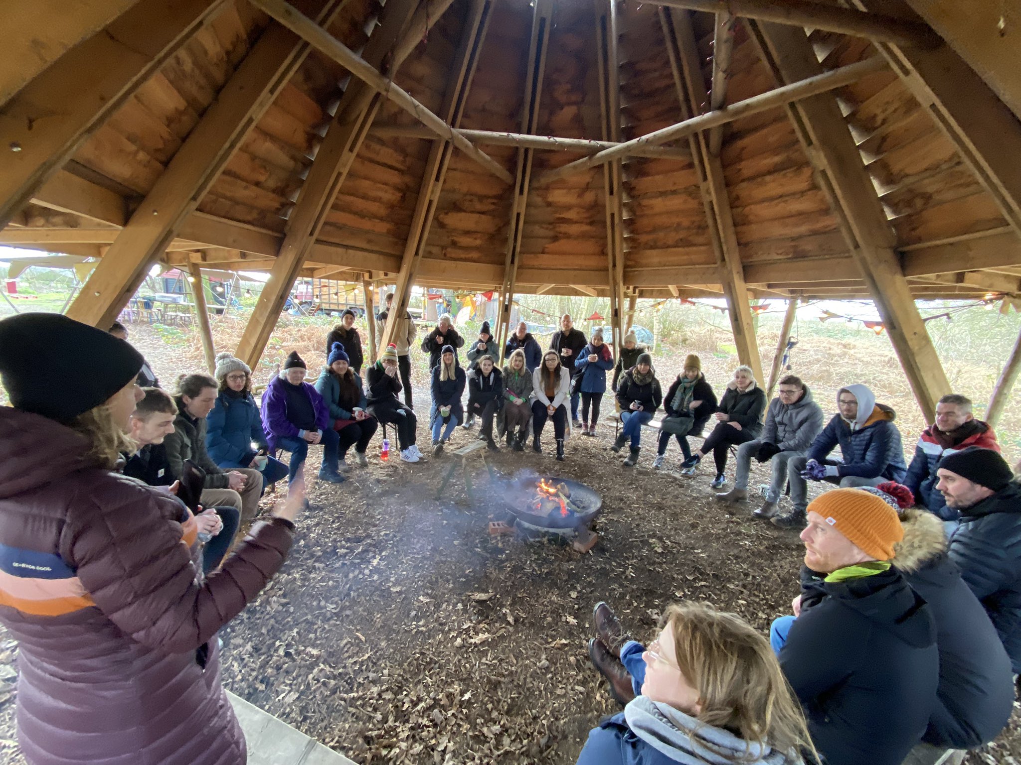 Our team gathers round a fire pit in the woods 