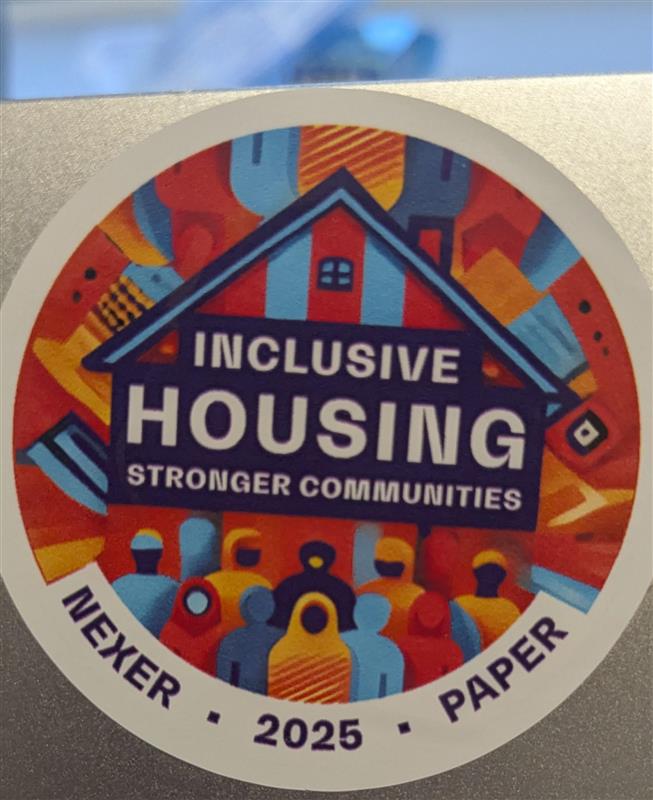 A sticker stuck on a laptop, which reads "Inclusive housing. Stronger Communities. Nexer and Paper 2025"