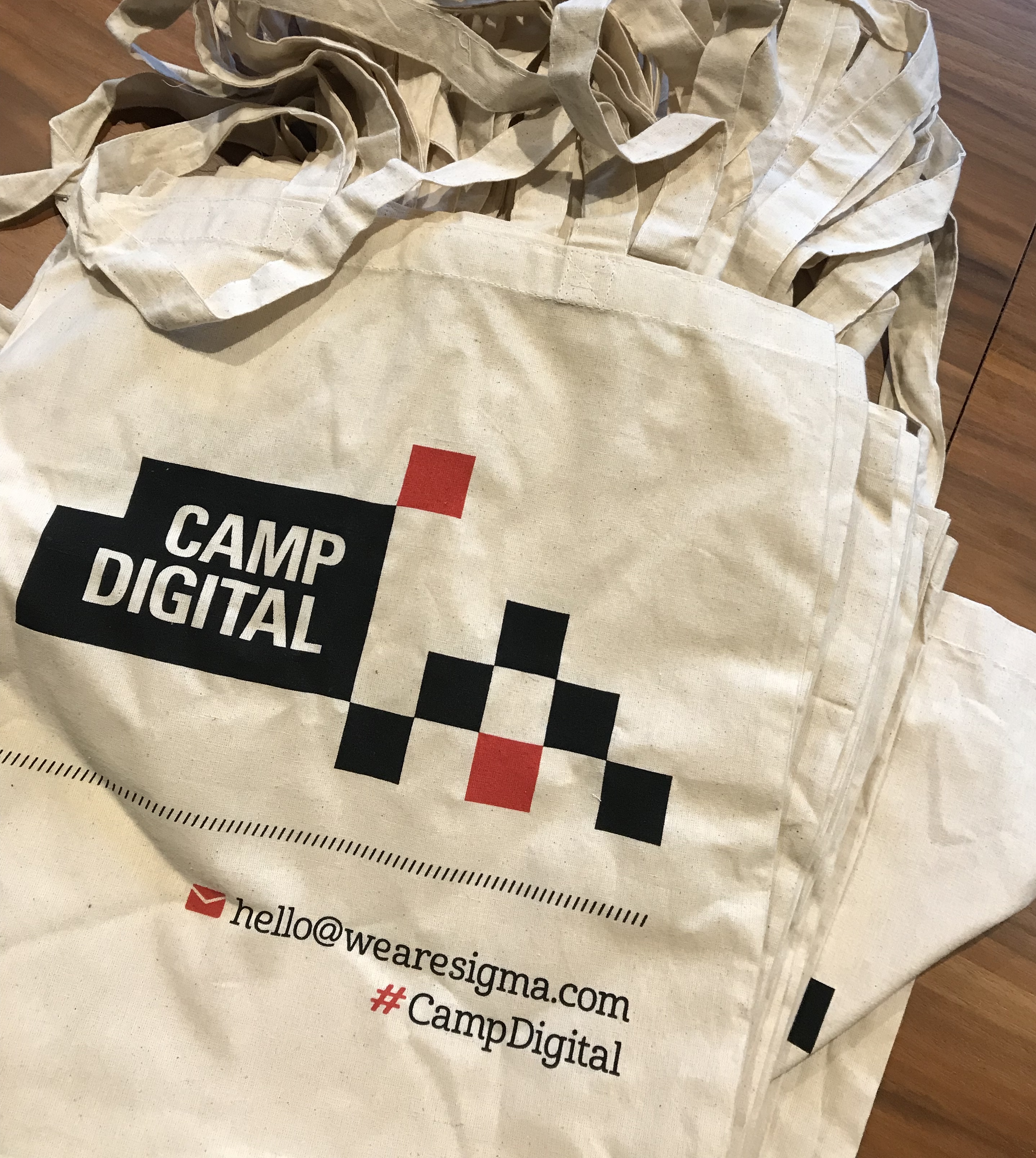 A stack of Camp Digital tote bags